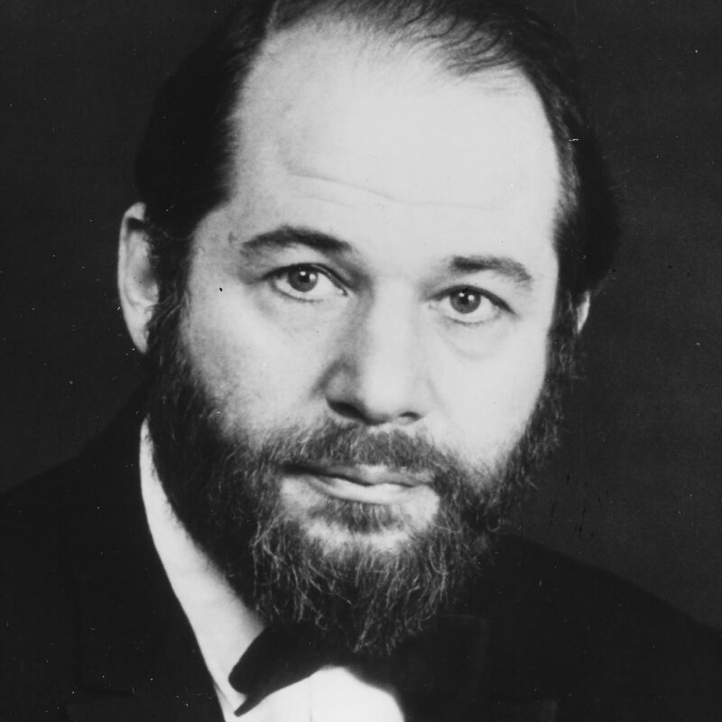 Portrait of Herbert Grossman, a middle-aged, bearded man formally-dressed in a classic tuxedo.